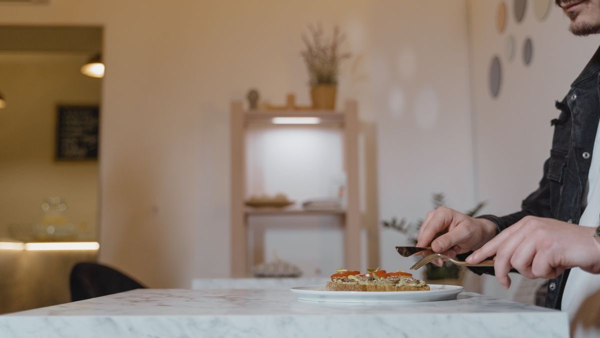 A man enjoying a healthy vegan meal in a cozy indoor cafe setting.